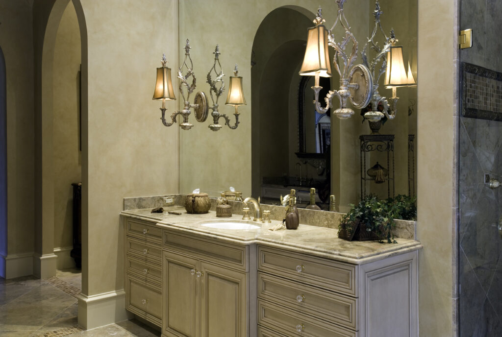 A cream colored bathroom with antique sconces