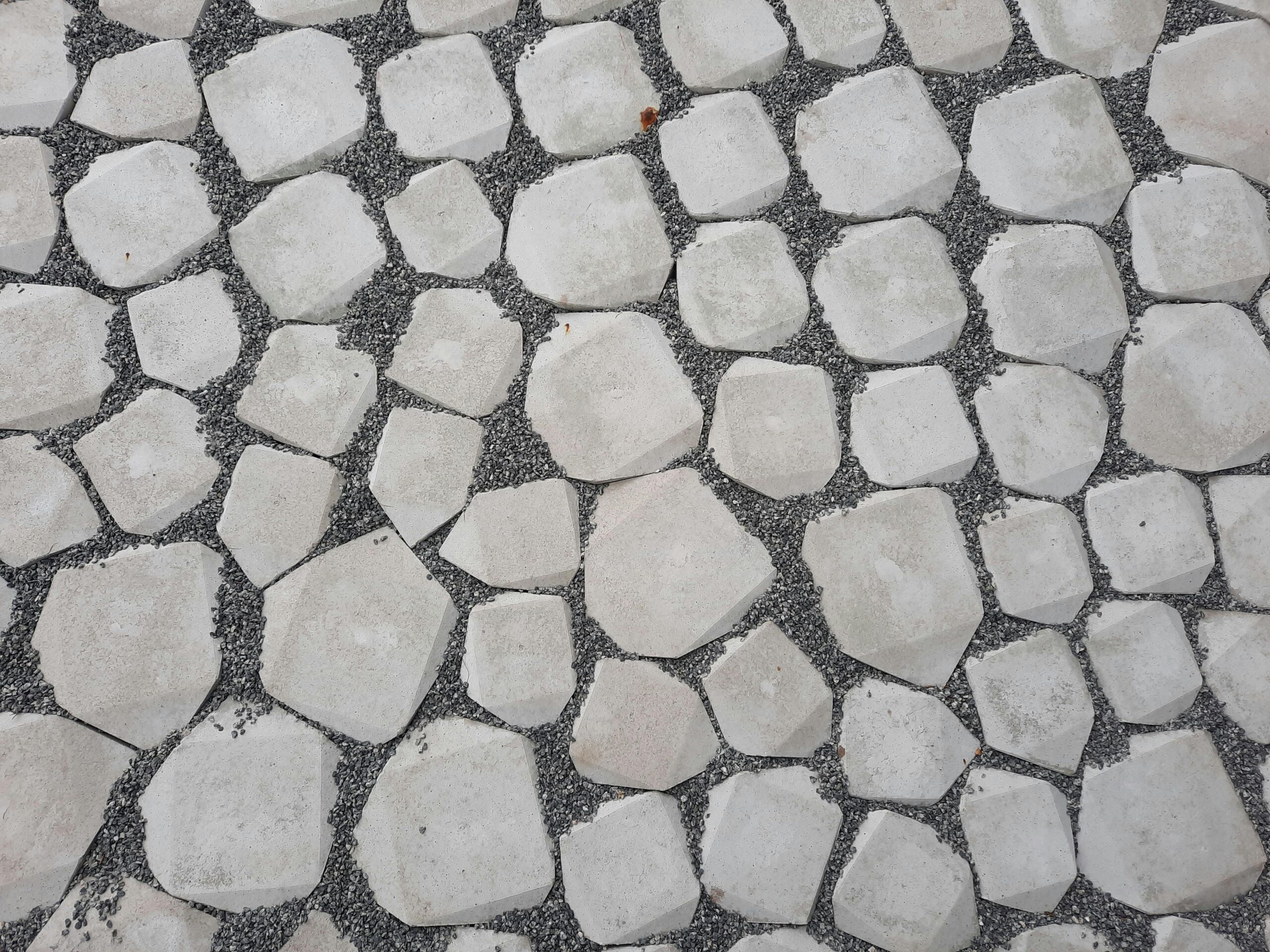 Top view of a geometric stone pathway with white rocks and gravel.