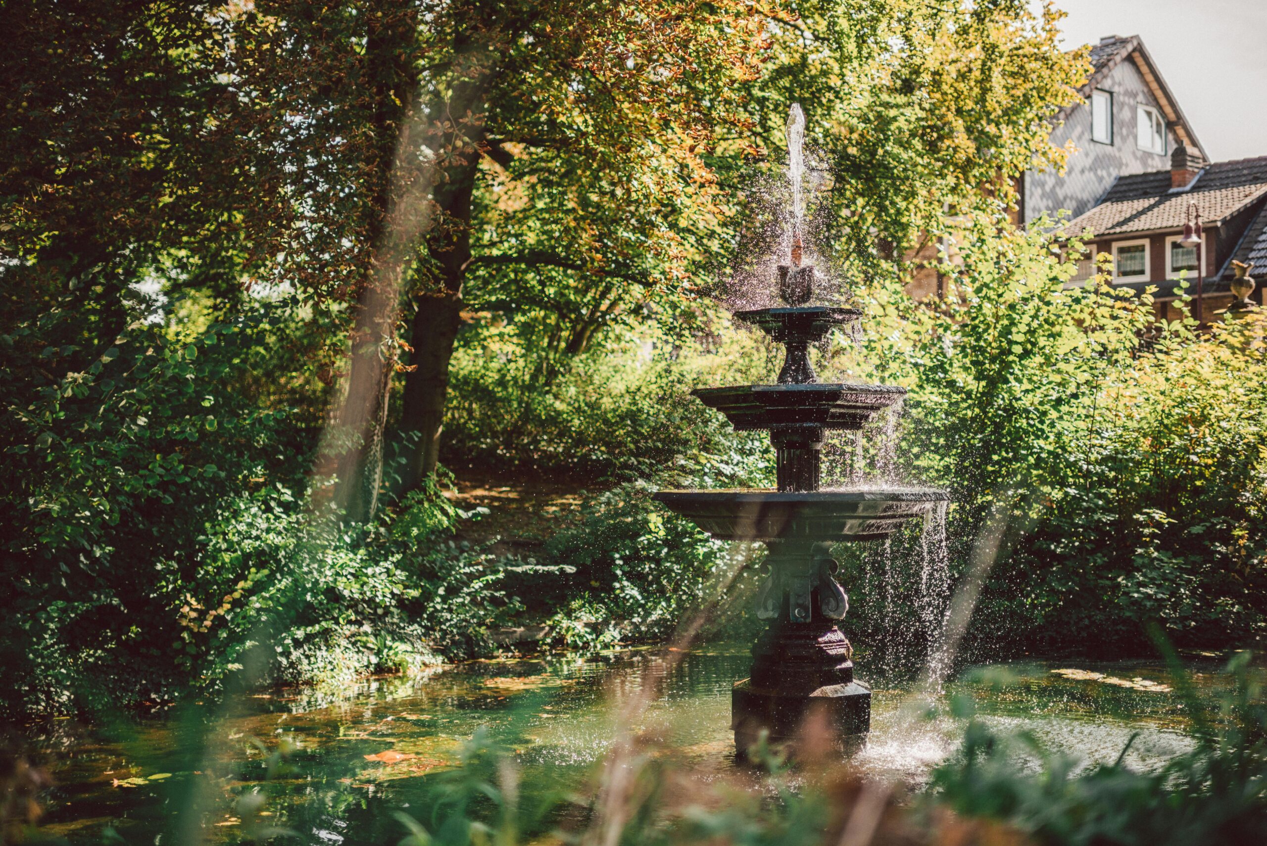 Serene fountain in a vibrant park setting in Einbeck, Germany.