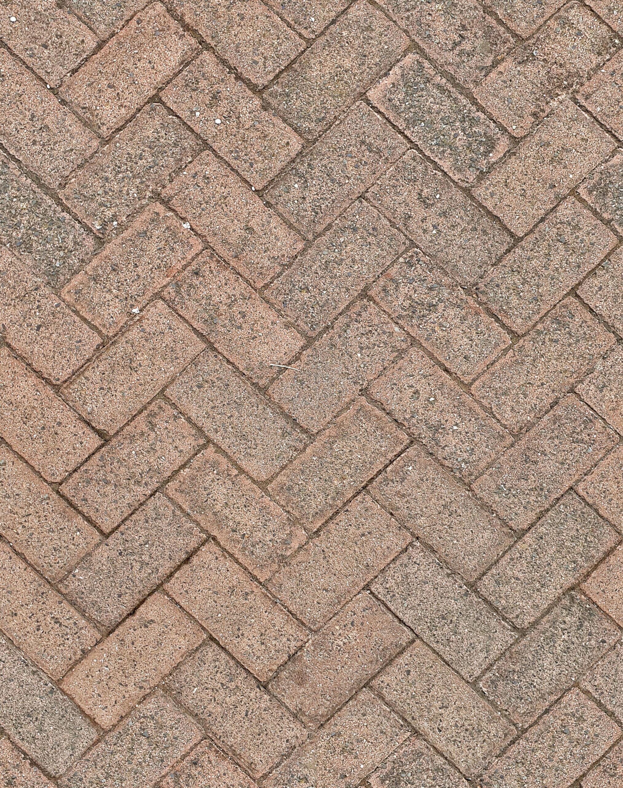 Close-up of herringbone patterned brick pavement, ideal for background texture.