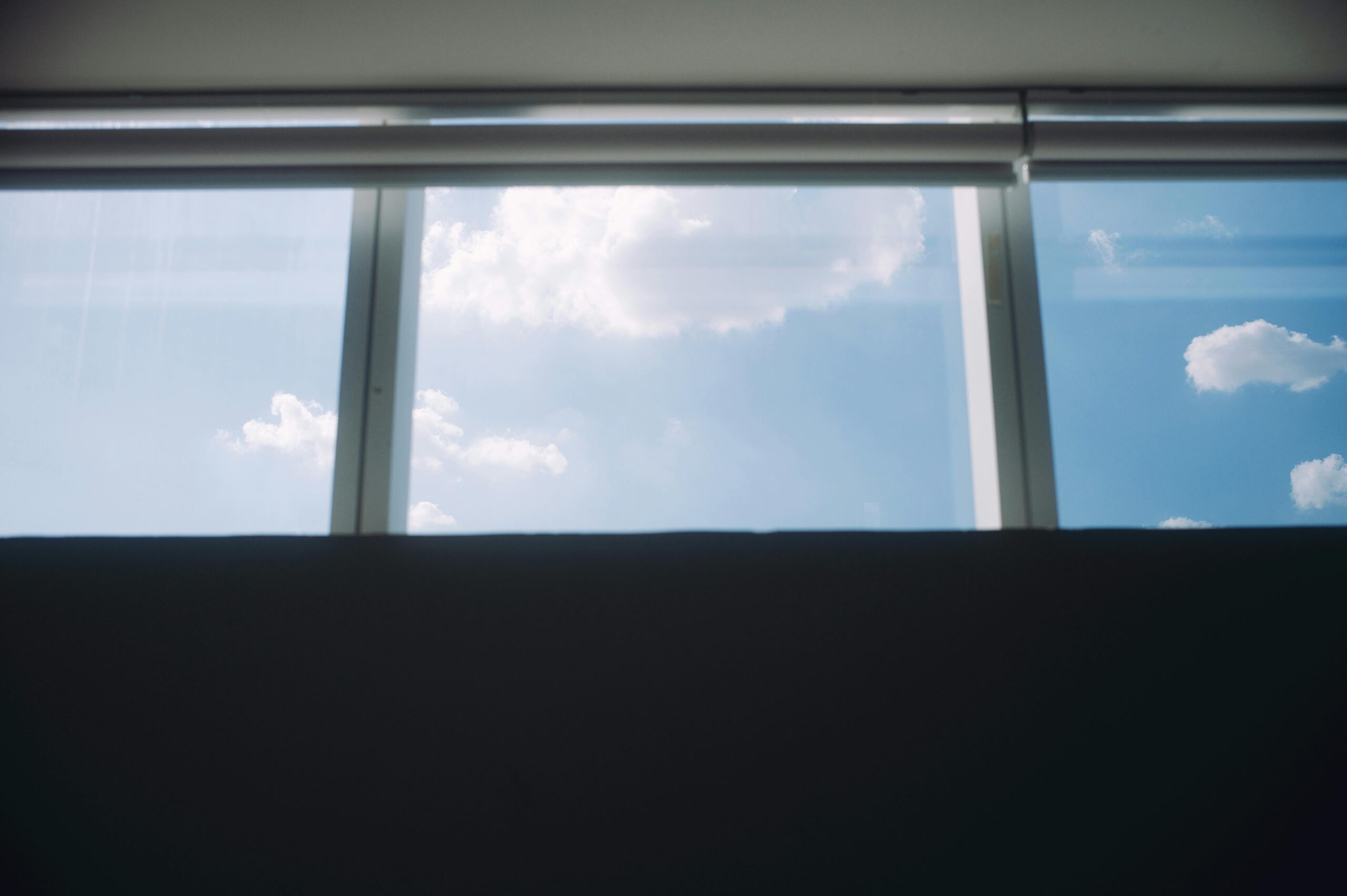 Cloudy sky visible through modern windows, offering a serene and minimalist view.