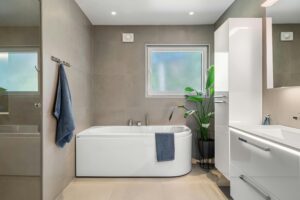 Minimalist bathroom featuring a white bathtub, sleek cabinetry, and modern fixtures.