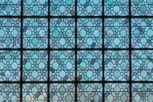 Intricate stained glass window pattern featuring blue geometric designs, perfect for religious or architectural themes.