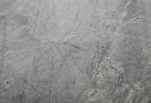 Close-up of a textured grey stone surface suitable for backgrounds or wallpapers.