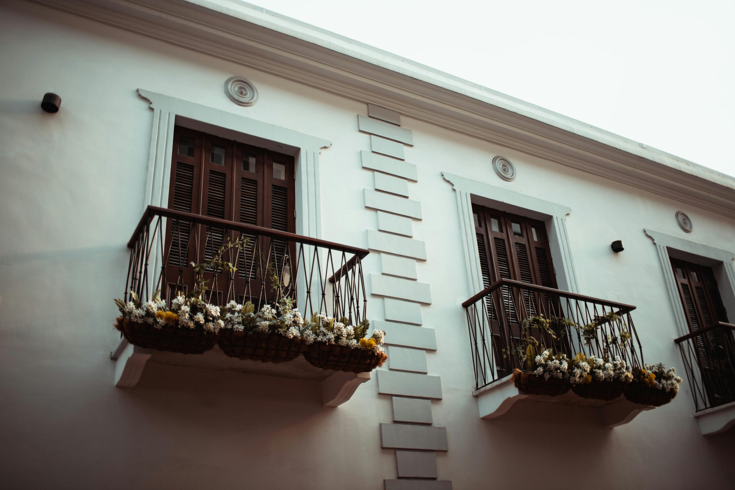 Beautiful balcony adorned with ornamental plants and flowers on a modern building facade.