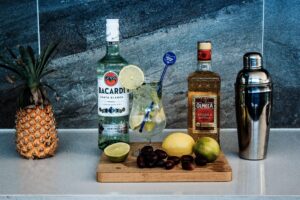 A vibrant cocktail with tropical fruits, rum, and tequila displayed on a countertop.