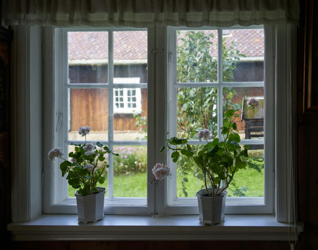 Charming window view with geraniums overlooking a countryside home in Lillehammer.
