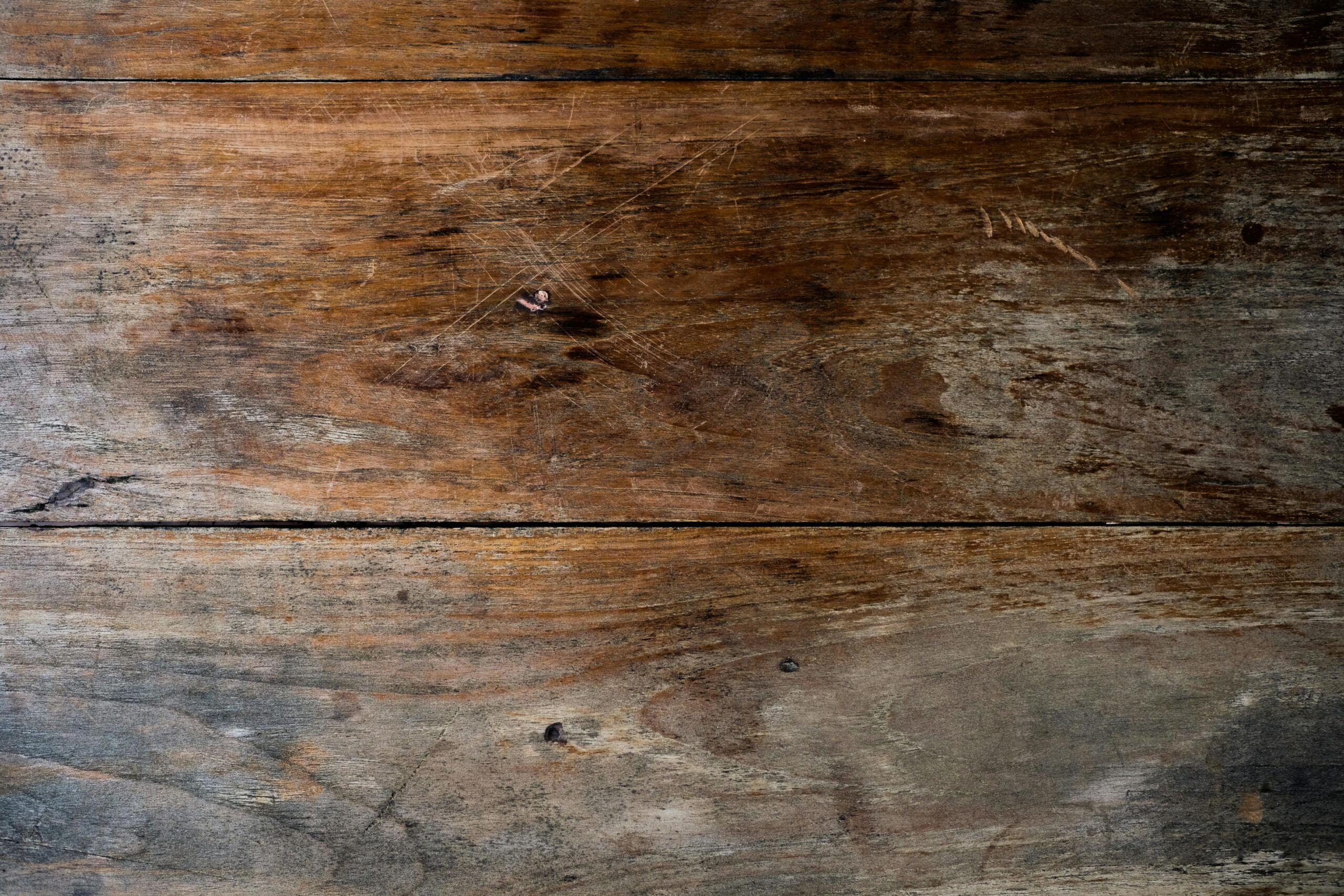 Close-up view of a rustic wooden plank with a textured, weathered finish ideal for backgrounds.