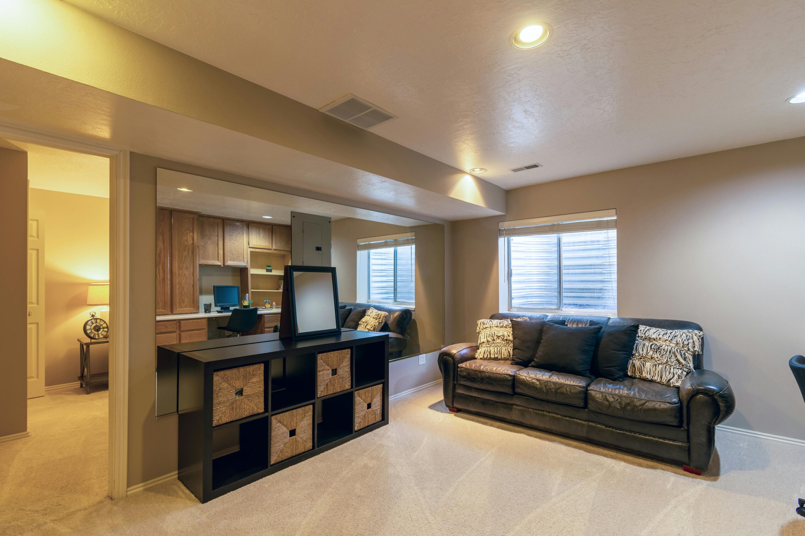 Warm and inviting basement living room featuring a leather sofa and modern decor.