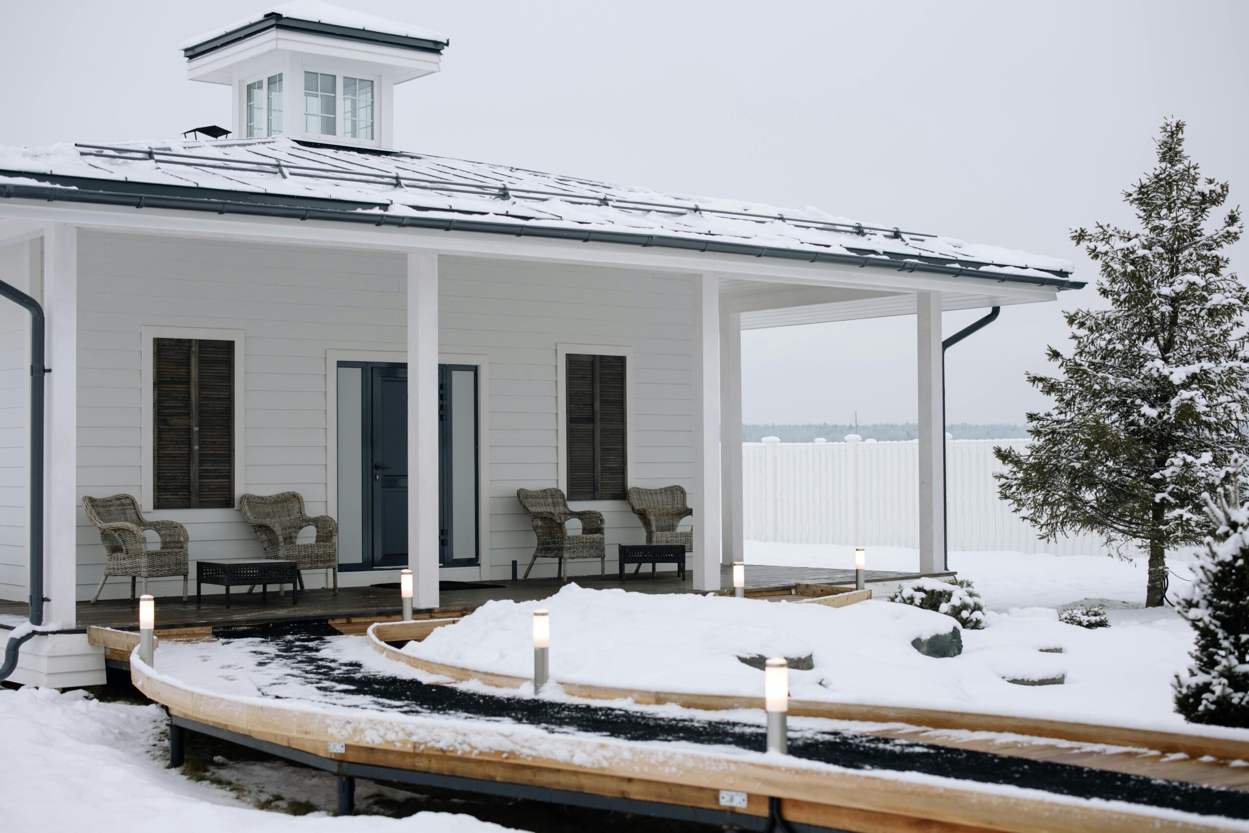 A cozy modern cabin surrounded by snow, featuring a stylish exterior design.