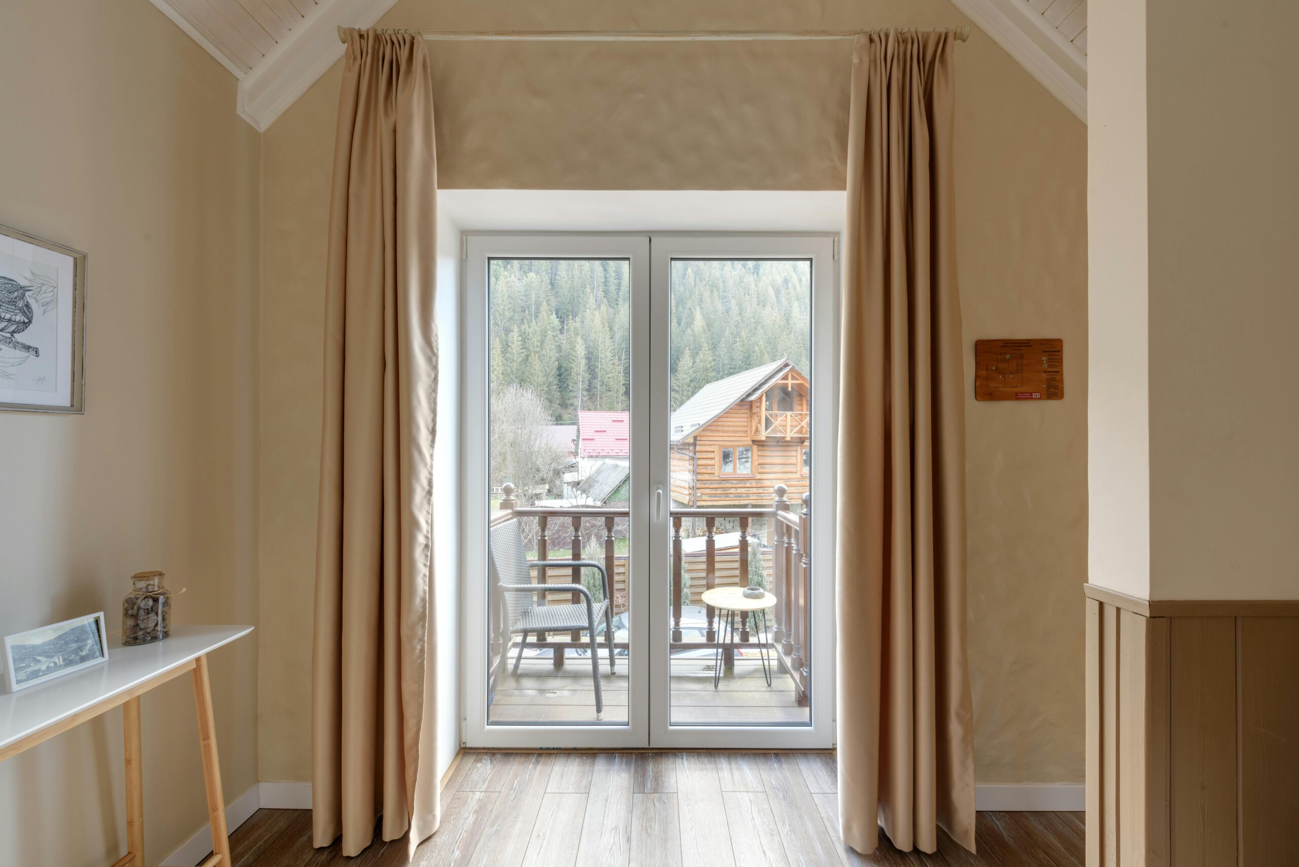 Interior shot of a cozy room with French doors opening to a scenic cabin view.