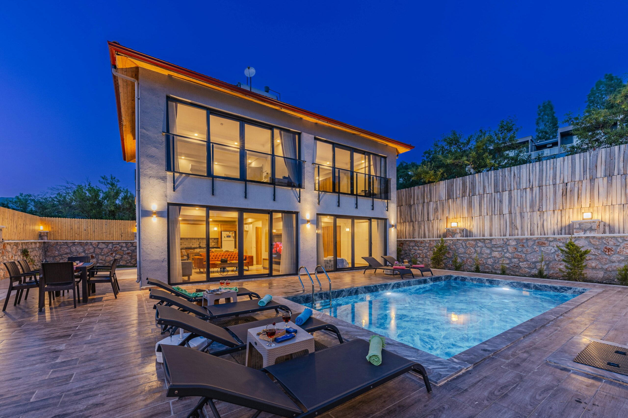 Modern luxury house with a swimming pool under twilight skies, offering serene outdoor living.